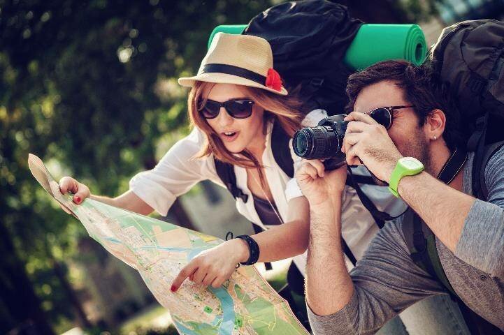 Man taking picture while woman looks at map