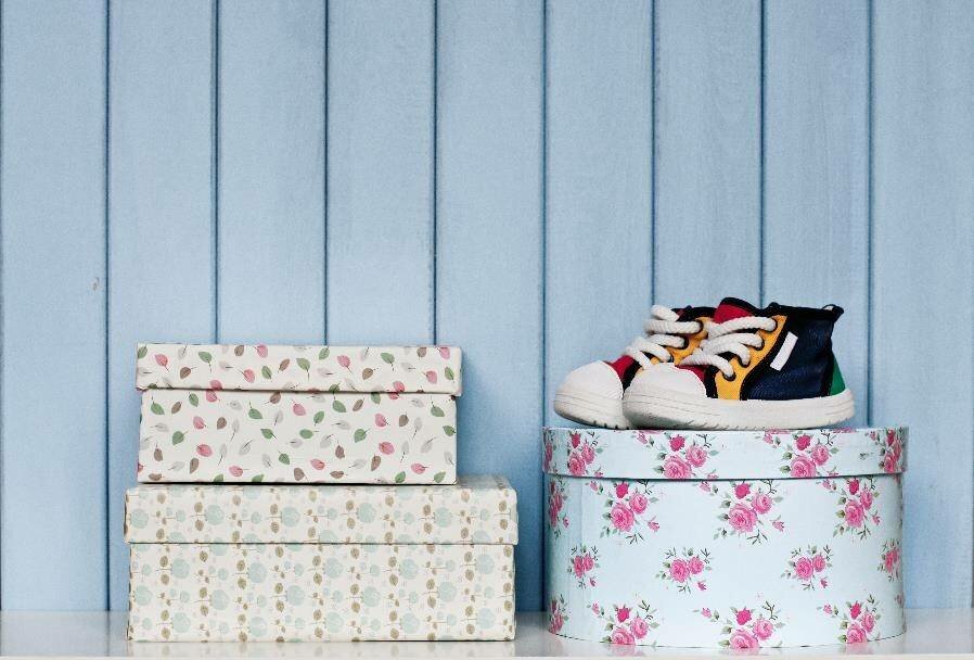 floral patterned boxes and a pair of child-sized shoes