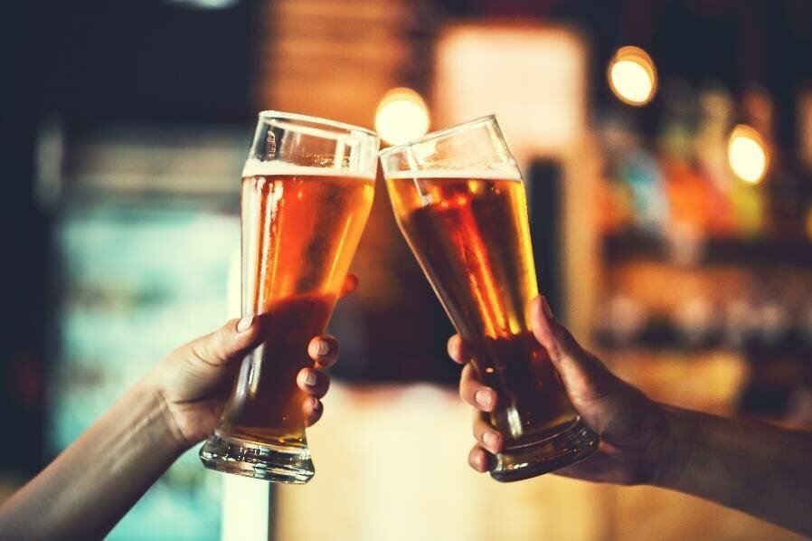 Two people clinking beer glasses.