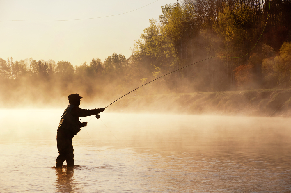 Fly fishermen casting into the river during sunrise 