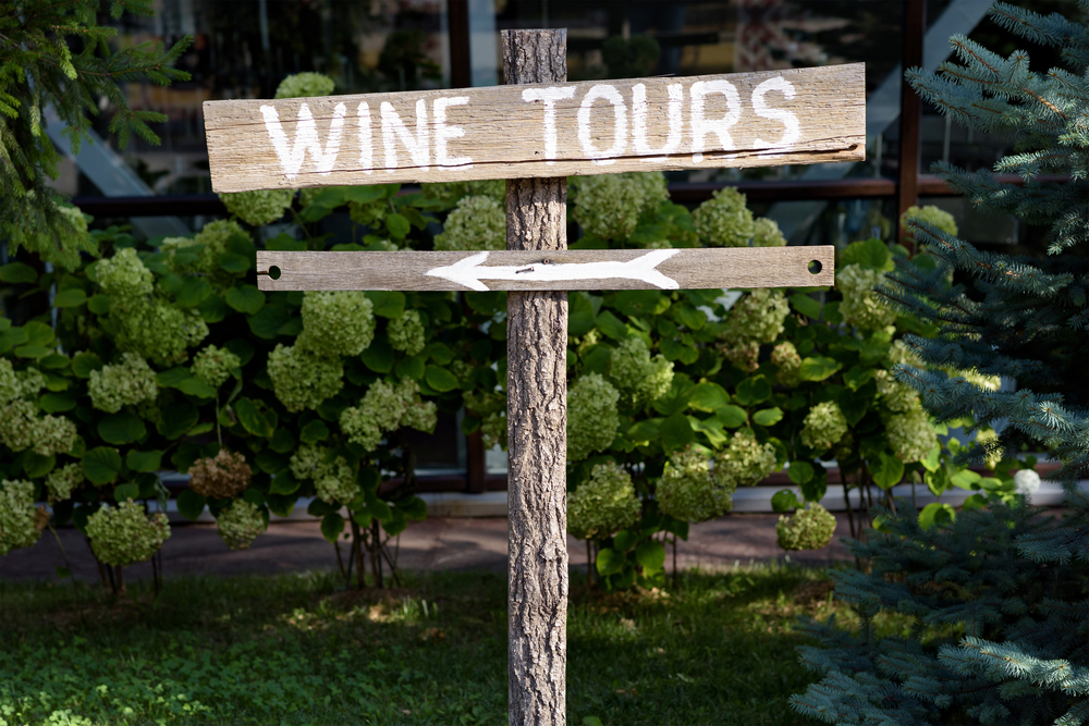 wooden sign that says wine tours with an arrow pointing towards the left side