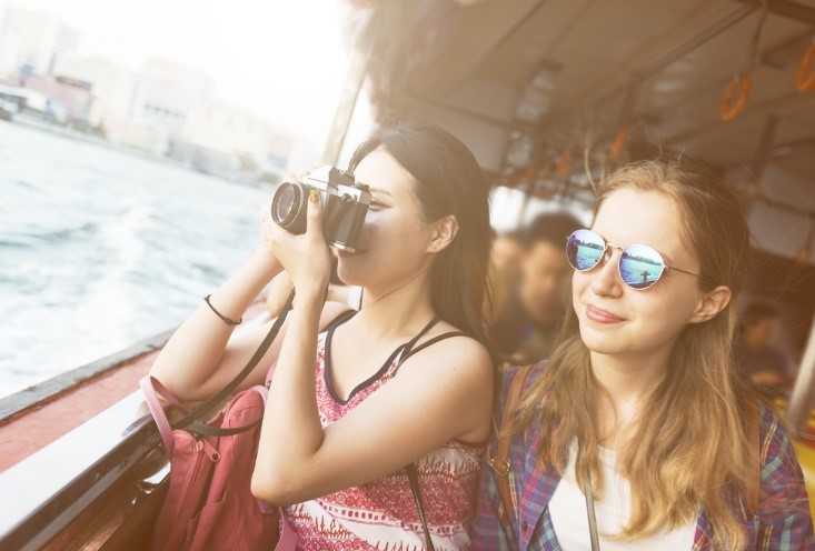 woman holding camera with friend next to her taking pictures