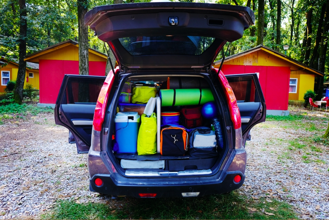 Car packed with camping gear in the forest